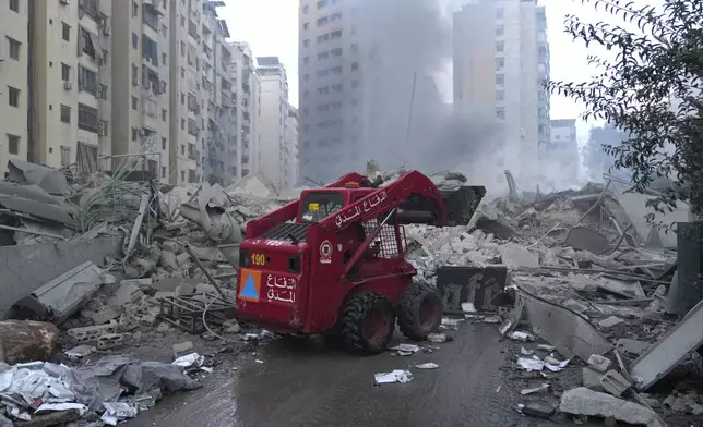 Civil Defense personnel remove debris from a destroyed complex hit by Israeli airstrikes in Dahieh, Beirut, Lebanon, Wednesday, Oct. 2, 2024.(AP Photo/Hussein Malla)