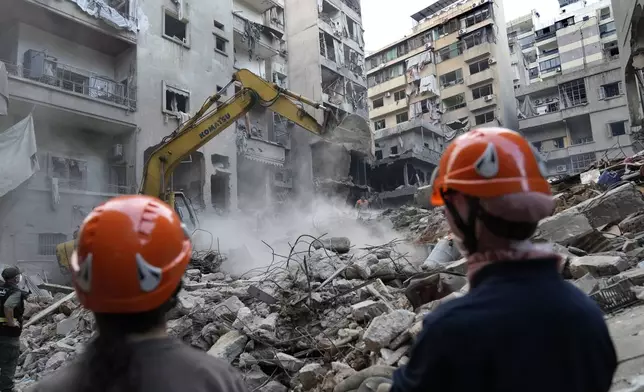 Rescue workers use an excavator to clear the rubble of destroyed buildings as they search for victims at the site of Thursday's Israeli airstrike, in Beirut, Lebanon, Friday, Oct. 11, 2024. (AP Photo/Hussein Malla)