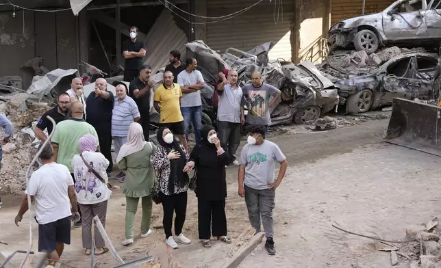 Residents react in front of their destroyed apartment at the site of Thursday's Israeli airstrike in Beirut, Lebanon, Friday, Oct. 11, 2024. (AP Photo/Hassan Ammar)