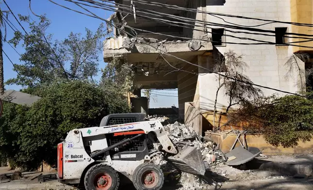 A worker uses a skid steer loader to remove the debris of a building that housed the office of pan-Arab TV channel Al-Mayadeen, which is politically allied with Hezbollah, that was hit Wednesday night by an Israeli airstrike, in southern Beirut, Lebanon, Thursday, Oct. 24, 2024. (AP Photo/Hussein Malla)