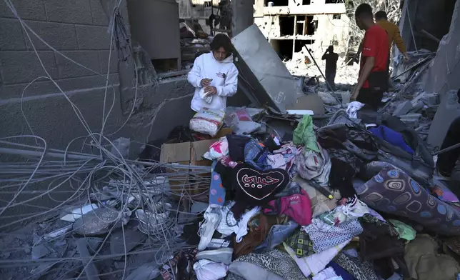 Lebanese citizens collect their belongings from their destroyed apartments that were hit by Israeli airstrikes, in Tyre, south Lebanon, Thursday, Oct. 24, 2024. (AP Photo/Mohammed Zaatari)