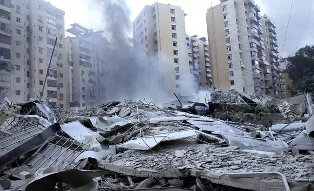 Smoke rises from a destroyed resident complex hit by Israeli airstrikes in Dahieh, Beirut, Lebanon, Wednesday, Oct. 2, 2024. (AP Photo/Hussein Malla)