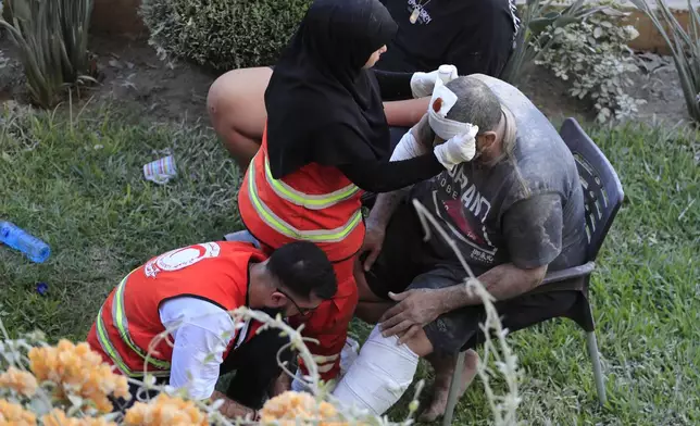 FILE - Paramedics treat a man who was injured after an Israeli airstrike hit two adjacent buildings east of the southern port city of Sidon, Lebanon, Sunday, Sept. 29, 2024. (AP Photo/Mohammed Zaatari, File)