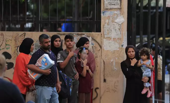 FILE - People fleeing the southern villages amid ongoing Israeli airstrikes, stand outside a school turned into a shelter in Sidon, Monday, Sept. 23, 2024. (AP Photo/Mohammed Zaatari, File)