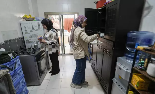 Zeinab Jaber, left, and her sister Fatima who were displaced from Mhaibib, a Lebanese border village with Israel, prepare coffee in their house in Aramoun village, southeast of Beirut, Lebanon, Saturday, Oct. 26, 2024. (AP Photo/Bilal Hussein)