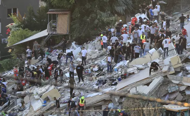 FILE - People and rescue workers search for victims after an Israeli airstrike hit two adjacent buildings, in Ain el-Delb neighborhood east of the southern port city of Sidon, Lebanon, Sunday, Sept. 29, 2024. (AP Photo/Mohammed Zaatari, File)