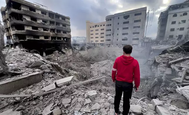 FILE - A man looks at destroyed buildings hit by Israeli airstrikes in the southern suburbs of Beirut, Lebanon, Monday, Oct. 7, 2024. (AP Photo/Hussein Malla, File)