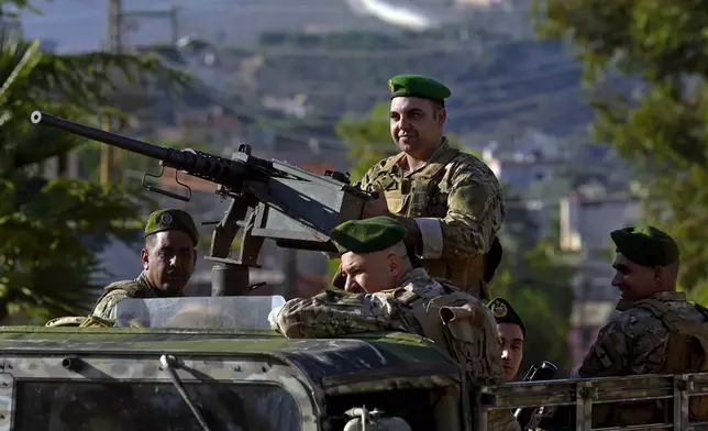 FILE - Lebanese army soldiers sit on their armored vehicle as they patrol the Lebanese side of the Lebanese-Israeli border in the southern village of Kfar Kila, Lebanon, on Oct. 13, 2023. (AP Photo/Bilal Hussein, File)