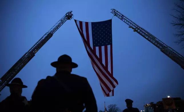 A garrison flag is adjusted before the funeral of Vanderburgh County Sheriff's Deputy Asson Hacker at Christian Fellowship Church on the evening of March 9, 2023. (Denny Simmons/Evansville Courier &amp; Press via AP)