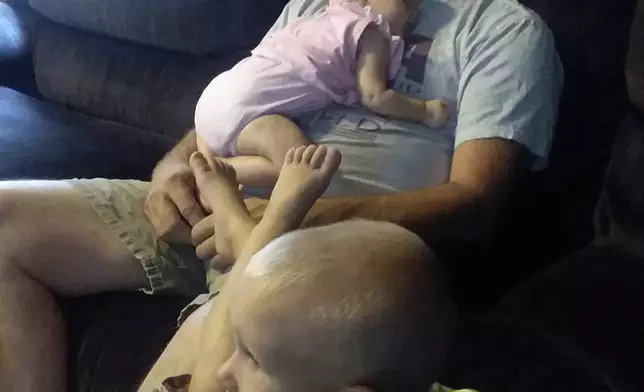 This photo provided by the family shows Edward Snukis with two of his grandchildren at home in Schuylkill Haven, Pa., on Aug. 20, 2019. Snukis, 55, died the next month after police officers in Evansville, Ind., shocked him with a Taser, punched him and held him face down. (Jill Snukis via AP)