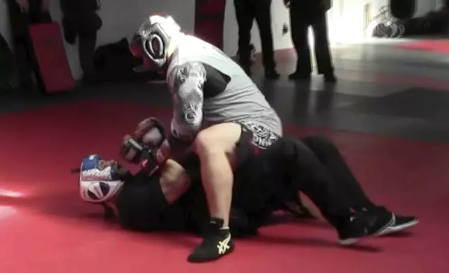 In this image from video made by the Evansville Police Department, rookie sheriff’s Deputy Asson Hacker, below, undergoes training with Mike Fisher, a sheriff's major from a nearby county, during "Big Fight" day for the Southwest Indiana Law Enforcement Academy in Evansville, Ind., on March 2, 2023. (Evansville Police Department via AP)