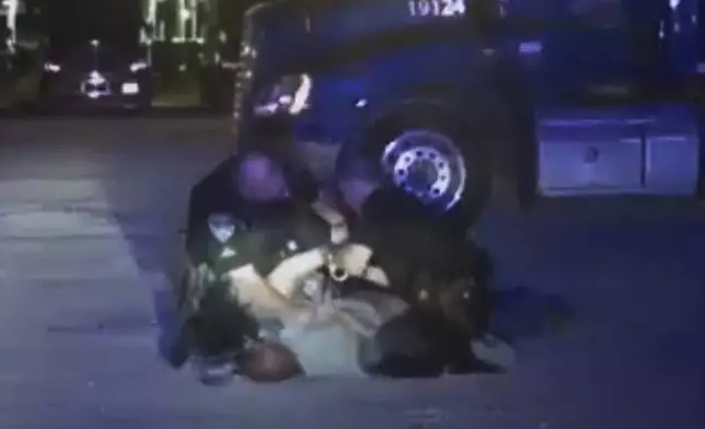 In this image from video provided by the Evansville Police Department, Edward Snukis, bottom center, is restrained by officers in Evansville, Ind., on Sept. 13, 2019. Snukis, 55, died after police officers shocked him with a Taser, punched him and held him face down. (Evansville Police Department via AP)