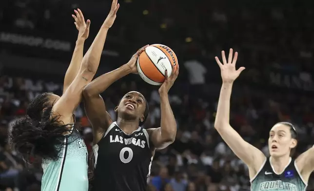 Las Vegas Aces guard Jackie Young (0) shoots over New York Liberty forward Betnijah Laney-Hamilton (44) during the first half of a WNBA Semifinal basketball game, Sunday, Oct. 6, 2024, in Las Vegas. (AP Photo/Ian Maule)