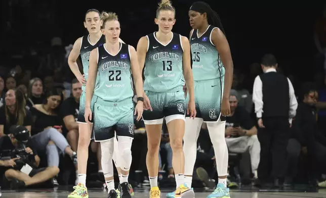 New York Liberty guard Courtney Vandersloot (22) and forward Leonie Fiebich (13) walk with teammates back into position during a WNBA basketball semifinal game against Las Vegas Aces Friday, Oct. 4, 2024, in Las Vegas. (AP Photo/Ronda Churchill)