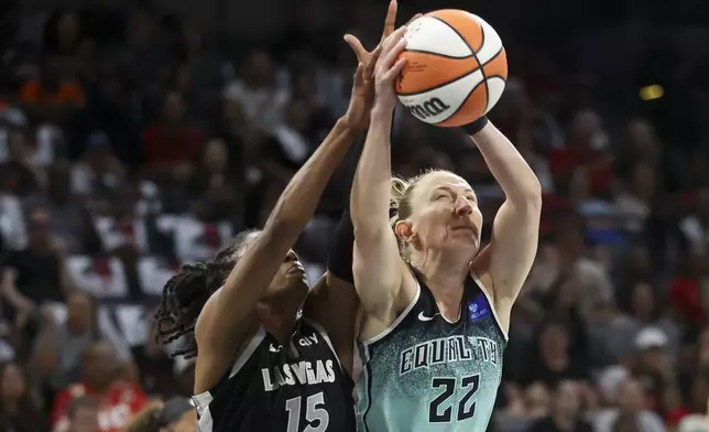 New York Liberty guard Courtney Vandersloot (22) grabs a rebound over Las Vegas Aces guard Tiffany Hayes (15) during the first half of a WNBA Semifinal basketball game, Sunday, Oct. 6, 2024, in Las Vegas. (AP Photo/Ian Maule)