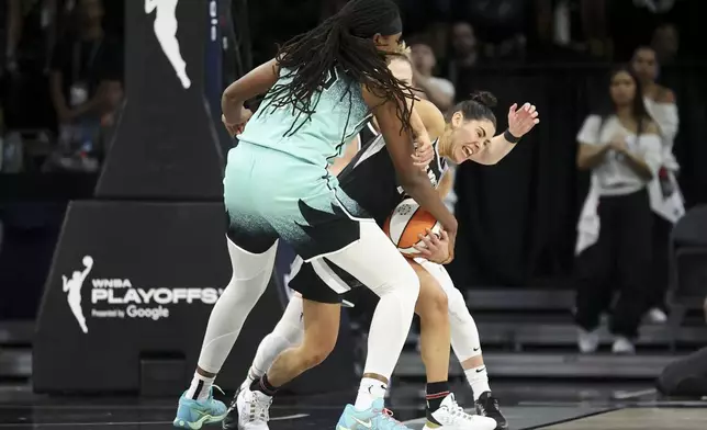 New York Liberty forward Jonquel Jones and guard Courtney Vandersloot defend Las Vegas Aces guard Kelsey Plum (10) during the second half of a WNBA Semifinal basketball game, Sunday, Oct. 6, 2024, in Las Vegas. (AP Photo/Ian Maule)