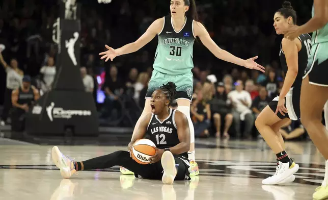 Las Vegas Aces guard Chelsea Gray (12) reacts to a call near New York Liberty forward Breanna Stewart (30) during a WNBA basketball semifinal game Friday, Oct. 4, 2024, in Las Vegas. (AP Photo/Ronda Churchill)