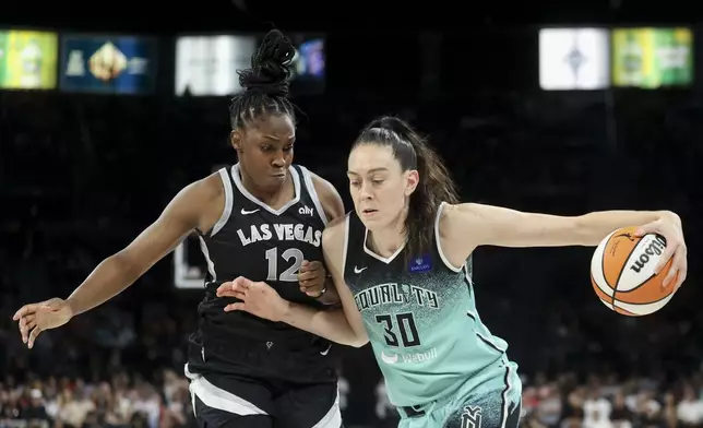 New York Liberty forward Breanna Stewart (30) drives past Las Vegas Aces guard Chelsea Gray (12) during the second half of a WNBA Semifinal basketball game, Sunday, Oct. 6, 2024, in Las Vegas. (AP Photo/Ian Maule)