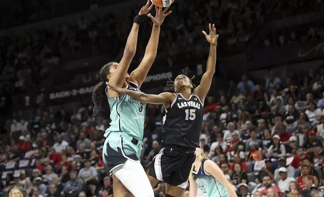 Las Vegas Aces guard Tiffany Hayes (15) is fouled by New York Liberty forward Nyara Sabally (8) during a WNBA basketball semifinal game Friday, Oct. 4, 2024, in Las Vegas. (AP Photo/Ronda Churchill)