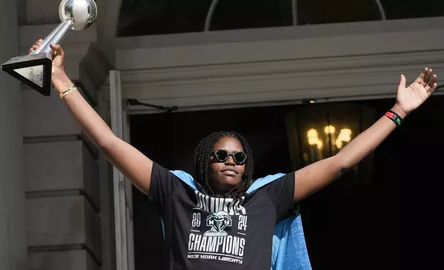 New York Liberty MVP Jonquel Jones greets the crowd as she arrives on stage during a ceremony after a parade in honor of the Liberty's WNBA basketball championship at City Hall in New York, Thursday, Oct. 24, 2024. (AP Photo/Seth Wenig)