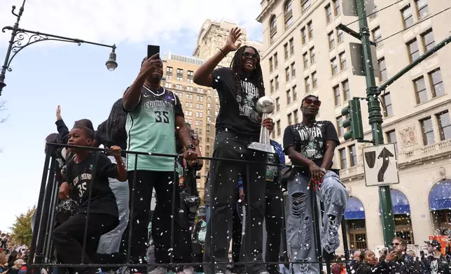 New York Liberty forward Jonquel Jones, center, waves as she rides on a float holding the MVP trophy to celebrate the team's WNBA basketball championship over the Minnesota Lynx, Thursday, Oct. 24, 2024, in New York. (AP Photo/Yuki Iwamura)