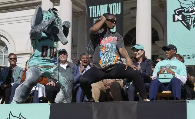 New York Liberty Kennedy Burke dances with the mascot, Ellie the Elephant, during a ceremony after a parade in honor of the Liberty's WNBA basketball championship at City Hall in New York, Thursday, Oct. 24, 2024. (AP Photo/Seth Wenig)