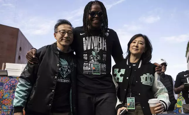 New York Liberty's owner Joe Tsai, left, and Clara Wu Tsai, right, pose with New York Liberty's center Jonquel Jones before the WNBA championship team's parade Thursday, Oct. 24, 2024, in New York. (AP Photo/Yuki Iwamura)