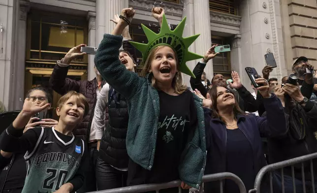 Spectators react as a float with members of the New York Liberty make its way up Broadway during the WNBA basketball championship parade Thursday, Oct. 24, 2024, in New York. (AP Photo/Yuki Iwamura)