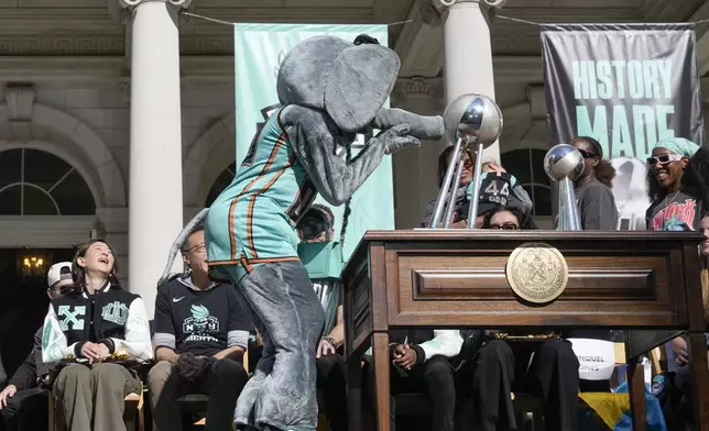 The New York Liberty mascot, Ellie the Elephant, kisses the championship trophy during a ceremony after a parade in honor of the Liberty's WNBA basketball championship at City Hall in New York, Thursday, Oct. 24, 2024. (AP Photo/Seth Wenig)