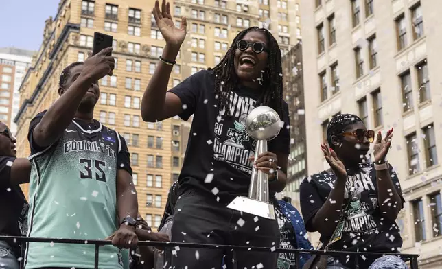 Members of the New York Liberty, including Jonquel Jones holding the MVP trophy, makes their way up Broadway during the WNBA basketball championship parade Thursday, Oct. 24, 2024, in New York. (AP Photo/Yuki Iwamura)