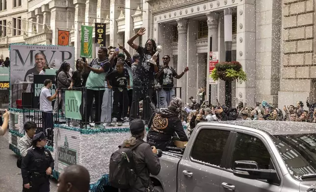 Members of the New York Liberty, including Jonquel Jones holding the MVP trophy, makes their way up Broadway during the WNBA basketball championship parade Thursday, Oct. 24, 2024, in New York. (AP Photo/Yuki Iwamura)