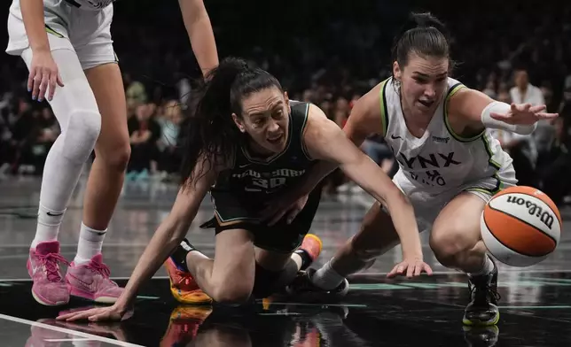 New York Liberty forward Breanna Stewart (30) and Minnesota Lynx forward Bridget Carleton (6) battle for a loose ball during the second quarter of Game 5 of the WNBA basketball final series, Sunday, Oct. 20, 2024, in New York. (AP Photo/Pamela Smith)