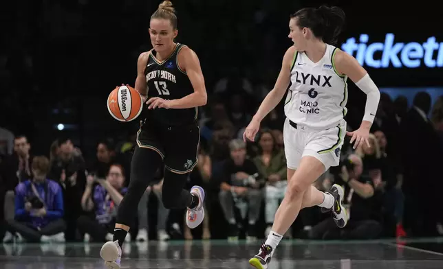 New York Liberty forward Leonie Fiebich (13) drives up the court against Minnesota Lynx forward Bridget Carleton (6) during the first quarter of Game 5 of the WNBA basketball final series, Sunday, Oct. 20, 2024, in New York. (AP Photo/Pamela Smith)