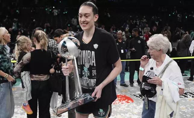 New York Liberty forward Breanna Stewart (30) holds the championship trophy after the Liberty defeated the Minnesota Lynx in Game 5 of the WNBA basketball final series, Sunday, Oct. 20, 2024, in New York. (AP Photo/Pamela Smith)