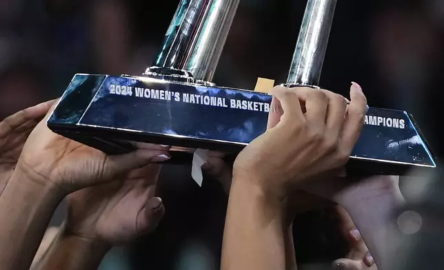 The New York Liberty hold up the championship trophy after defeating the Minnesota Lynx in Game 5 of the WNBA basketball final series, Sunday, Oct. 20, 2024, in New York. (AP Photo/Pamela Smith)