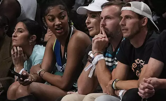 Angel Reese, second from left, watches play between the New York Liberty and the Minnesota Lynx during Game 5 of the WNBA basketball final series, Sunday, Oct. 20, 2024, in New York. (AP Photo/Pamela Smith)