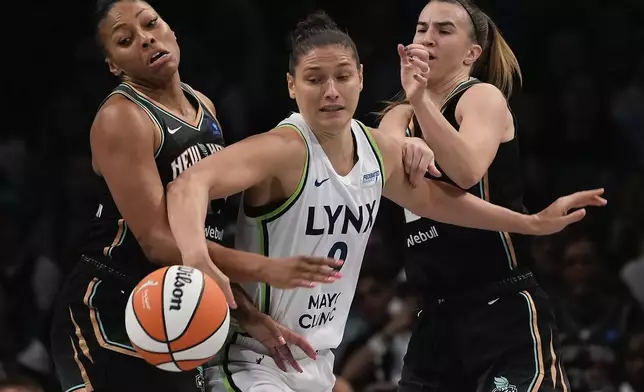 Minnesota Lynx forward Cecilia Zandalasini (9) battles for a loose ball against New York Liberty forward Betnijah Laney-Hamilton, left, and guard Sabrina Ionescu, right, during the second quarter of Game 5 of the WNBA basketball final series, Sunday, Oct. 20, 2024, in New York. (AP Photo/Pamela Smith)