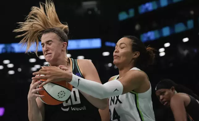 New York Liberty guard Sabrina Ionescu (20) battles for a rebound against Minnesota Lynx forward Napheesa Collier (24) during the fourth quarter of Game 5 of the WNBA basketball final series, Sunday, Oct. 20, 2024, in New York. (AP Photo/Pamela Smith)