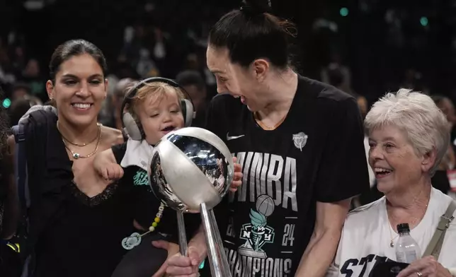 New York Liberty forward Breanna Stewart reacts with her daughter, Ruby, while holding the championship trophy after the Liberty won Game 5 of the WNBA basketball final series against the Minnesota Lynx, Sunday, Oct. 20, 2024, in New York. (AP Photo/Pamela Smith)