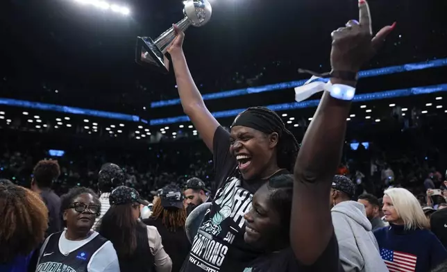 New York Liberty forward Jonquel Jones, left, holds up the MVP award after the Liberty defeated the Minnesota Lynx in Game 5 of the WNBA basketball final series, Sunday, Oct. 20, 2024, in New York. (AP Photo/Pamela Smith)