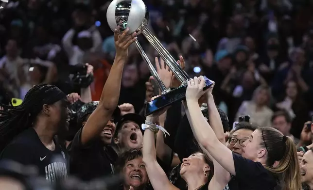 The New York Liberty hold up the championship trophy after defeating the Minnesota Lynx in Game 5 of the WNBA basketball final series, Sunday, Oct. 20, 2024, in New York. (AP Photo/Pamela Smith)