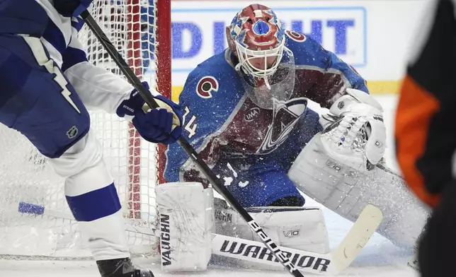 Showered with snow, Colorado Avalanche goaltender Kaapo Kahkonen stops a shot off the stick of Tampa Bay Lightning defenseman Victor Hedman in the second period of an NHL hockey game Wednesday, Oct. 30, 2024, in Denver. (AP Photo/David Zalubowski)