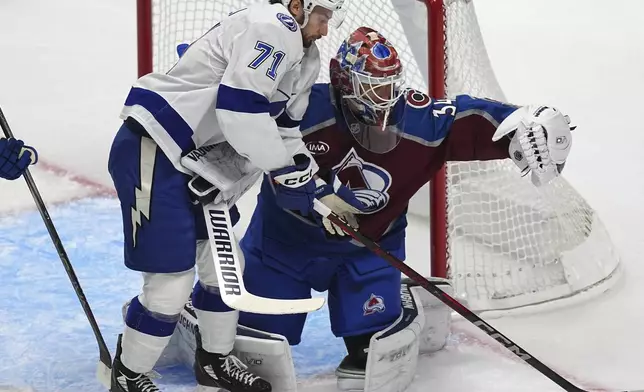 Colorado Avalanche goaltender Kaapo Kahkonen, right, makes a glove save of a shot as Tampa Bay Lightning center Anthony Cirelli covers in the first period of an NHL hockey game Wednesday, Oct. 30, 2024, in Denver. (AP Photo/David Zalubowski)