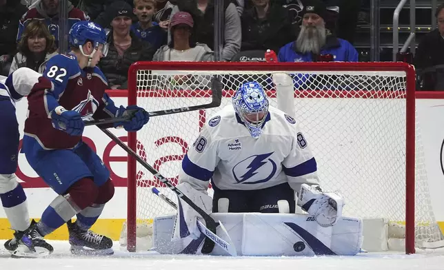 Tampa Bay Lightning goaltender Andrei Vasilevskiy, right, makes a pad save of a shot from Colorado Avalanche center Ivan Ivan in the second period of an NHL hockey game Wednesday, Oct. 30, 2024, in Denver. (AP Photo/David Zalubowski)