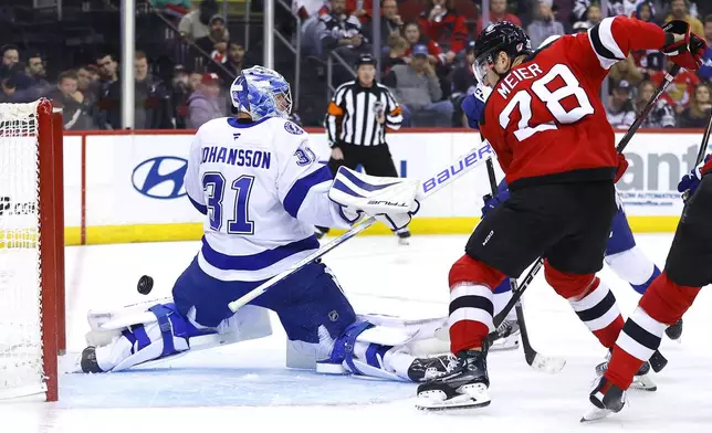 New Jersey Devils right wing Timo Meier (28) misses a shot at the goal against Tampa Bay Lightning goaltender Jonas Johansson (31) during the second period of a NHL hockey game, Tuesday Oct. 22, 2024, in Newark, N.J. (AP Photo/Noah K. Murray)