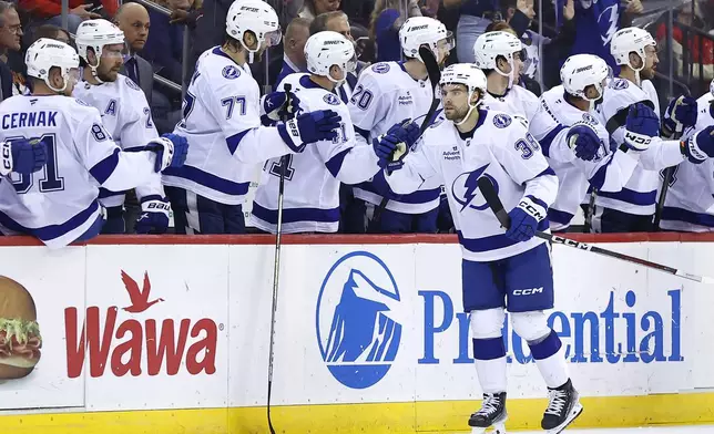 Tampa Bay Lightning left wing Brandon Hagel (38) celebrates with teammates after scoring a goal against the New Jersey Devils during the second period of a NHL hockey game, Tuesday Oct. 22, 2024, in Newark, N.J. (AP Photo/Noah K. Murray)