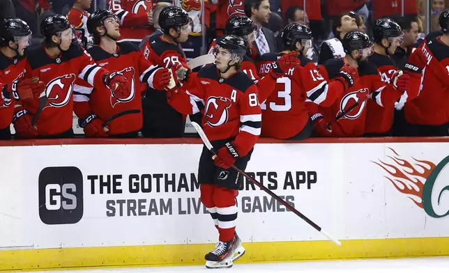 New Jersey Devils center Jack Hughes (86) celebrates with teammates after scoring a goal against the Tampa Bay Lightning during the first period of a NHL hockey game, Tuesday Oct. 22, 2024, in Newark, N.J. (AP Photo/Noah K. Murray)