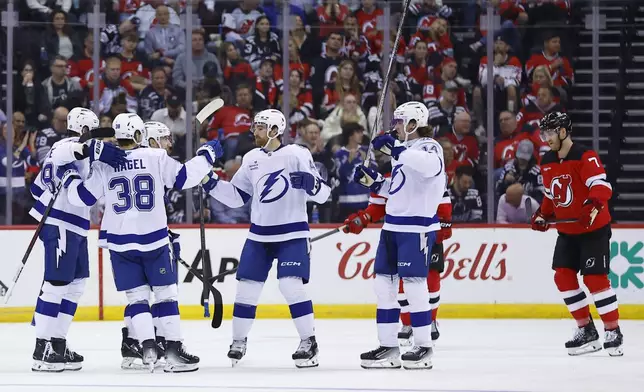 Tampa Bay Lightning left wing Brandon Hagel (38) celebrates with teammates after scoring a goal against the New Jersey Devils during the second period of a NHL hockey game, Tuesday Oct. 22, 2024, in Newark, N.J. (AP Photo/Noah K. Murray)