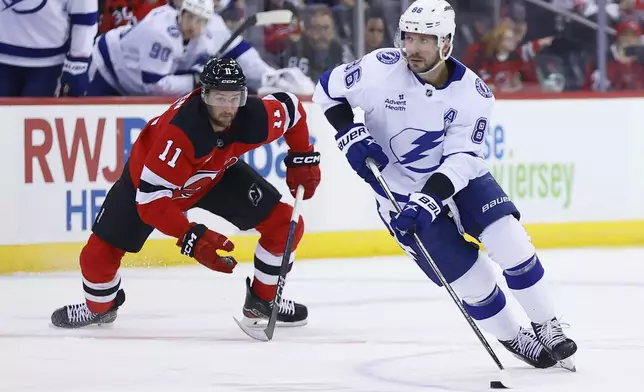 Tampa Bay Lightning right wing Nikita Kucherov (86) skates with the puck against New Jersey Devils right wing Stefan Noesen (11) during the first period of a NHL hockey game, Tuesday Oct. 22, 2024, in Newark, N.J. (AP Photo/Noah K. Murray)