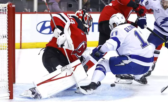 New Jersey Devils goaltender Jake Allen (34) makes a save againstTampa Bay Lightning center Luke Glendening (11) during the first period of a NHL hockey game, Tuesday Oct. 22, 2024, in Newark, N.J. (AP Photo/Noah K. Murray)